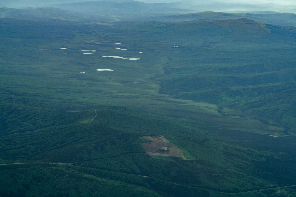 A cleared industrial pad on lowland flats with ponds beyond, from the air