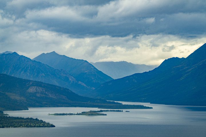A long mountain lake below storm cloud