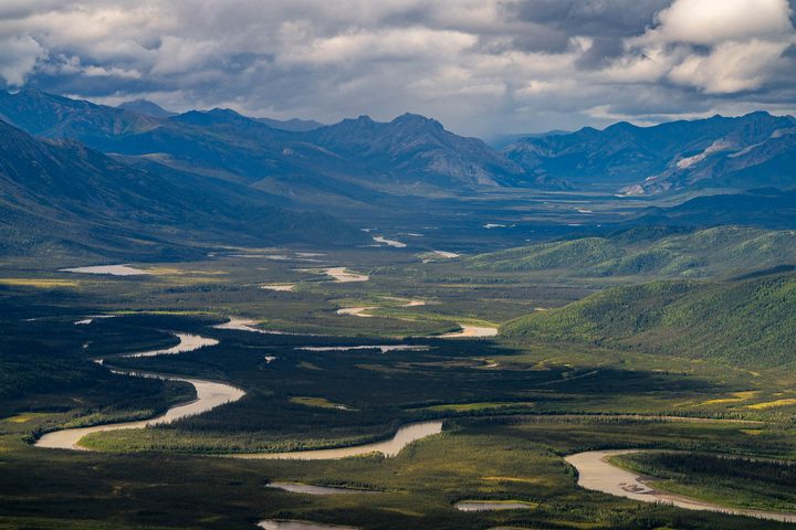A wide river valley running between dark mountain ridges