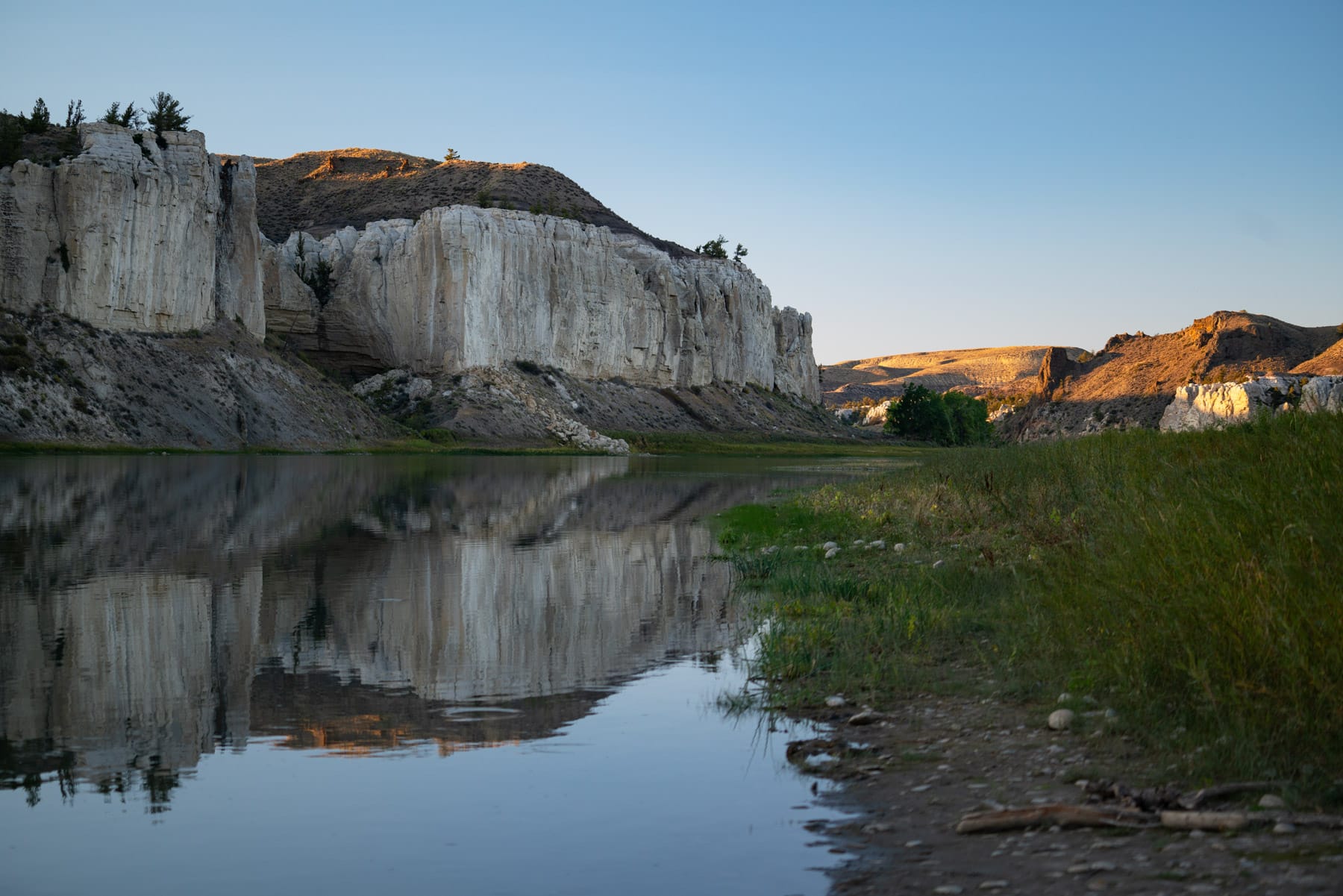 The White Cliffs of the Missouri at evening, the cliff face doubled in still water