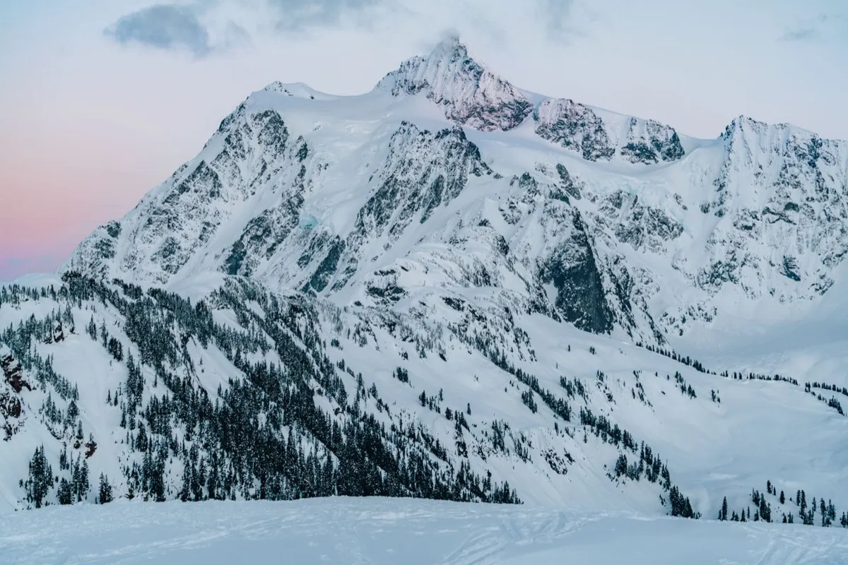 Snowbound peaks and forested ridges of the North Cascades at dusk