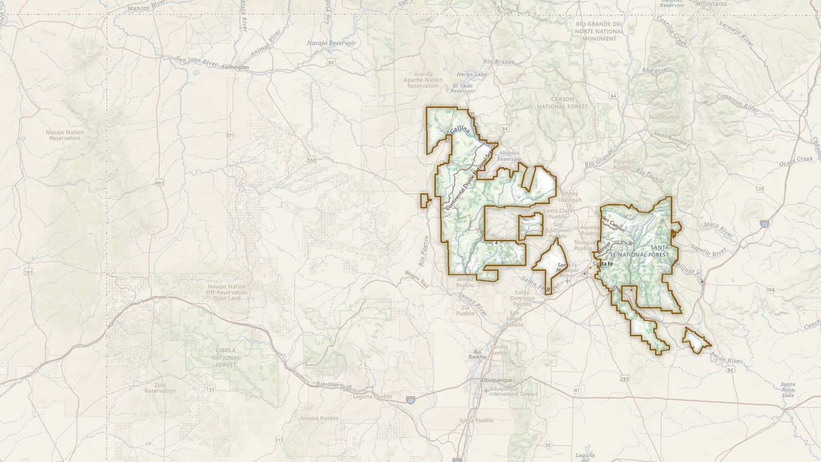 The boundary of the Santa Fe National Forest drawn on the USGS topographic map, with the towns, highways and rivers around it.