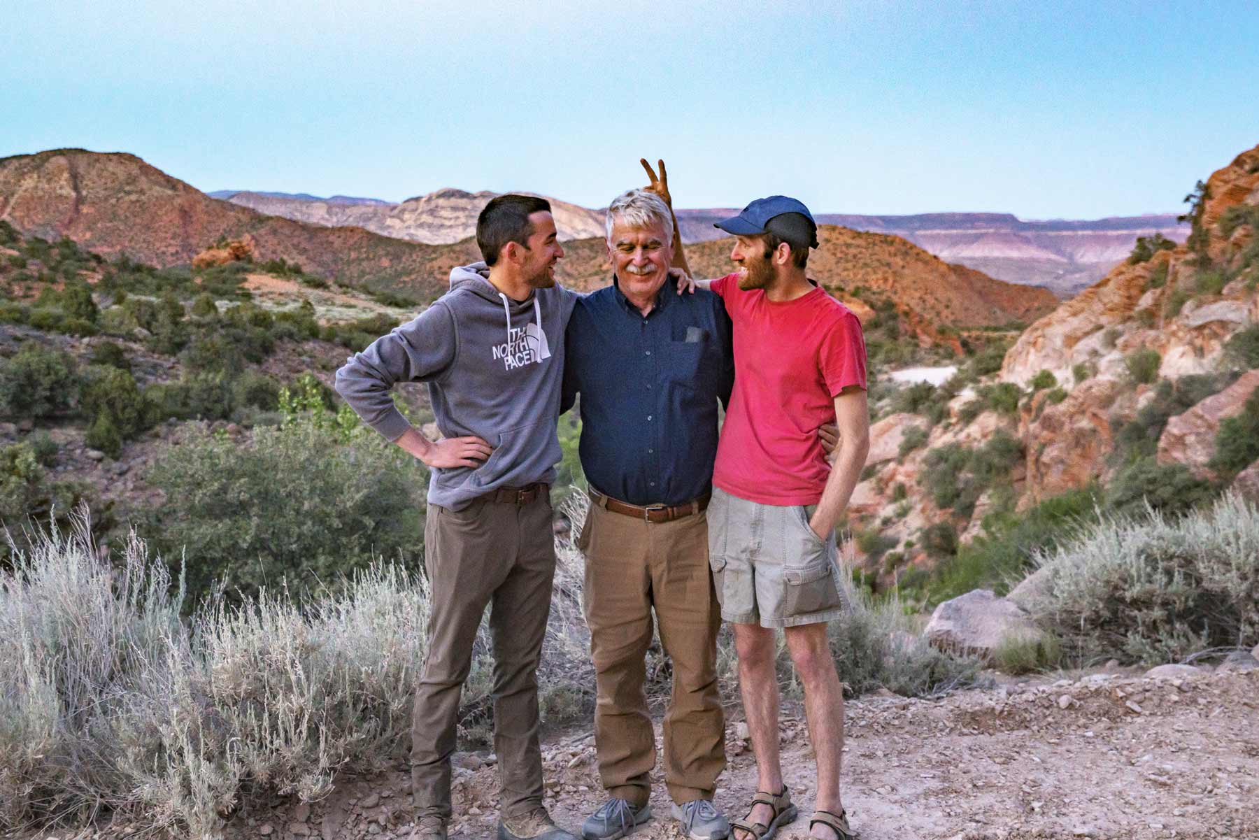 Jim, Tony, and Will Pattiz stand in a desert landscape.