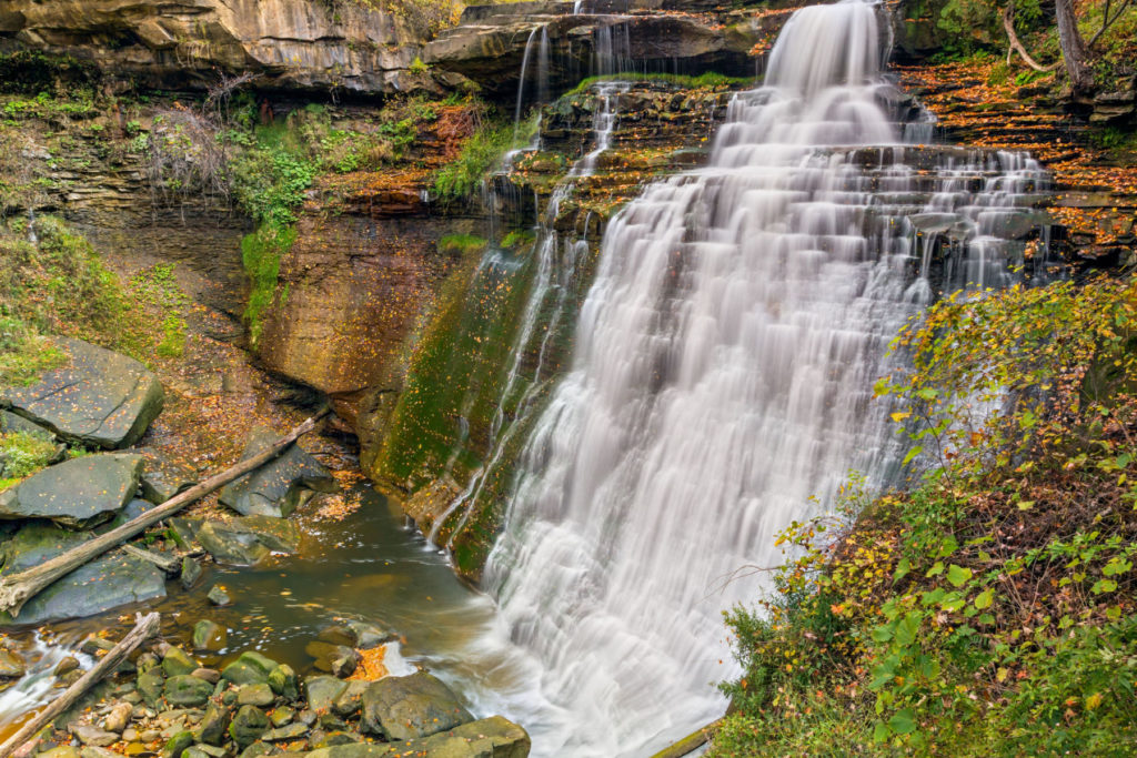 The Brandywine Falls waterfall drops down dark rocks into a pool of water below.