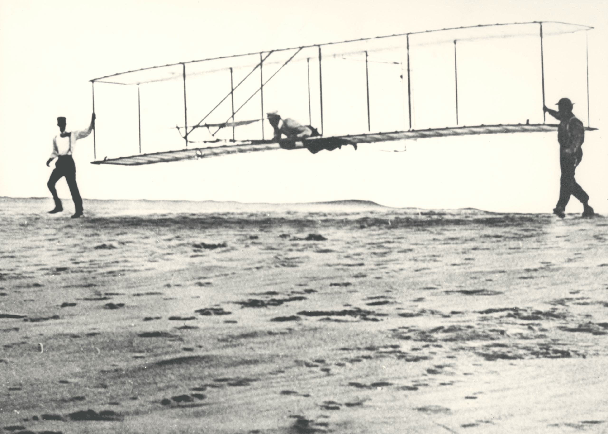 Historic photo of the Wright brothers' third test glider being launched at Kill Devil Hills