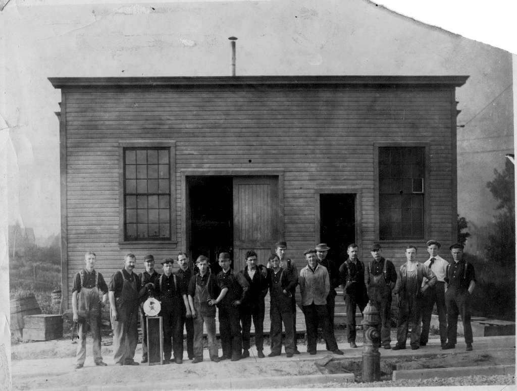 The four founders of Harley-Davidson Motor Company -William A. Harley, and Walter, Arthur and William Davidson – posed with the entire staff in 1907. The picture was taken in front of the factory building they used prior to the one that was built in 1912.