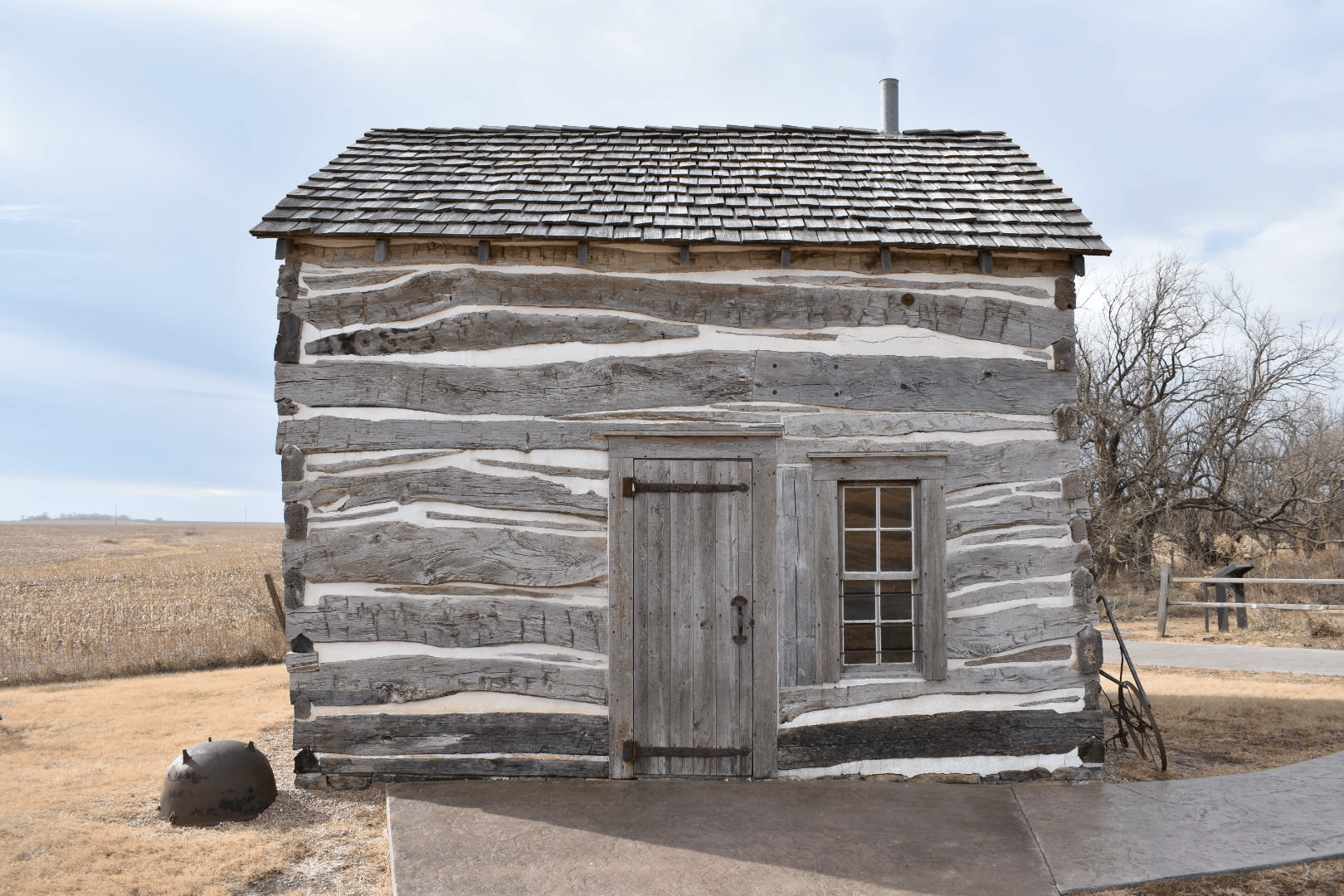 Palmer-Epard Cabin with interpretive equipment and open prairie landscape
