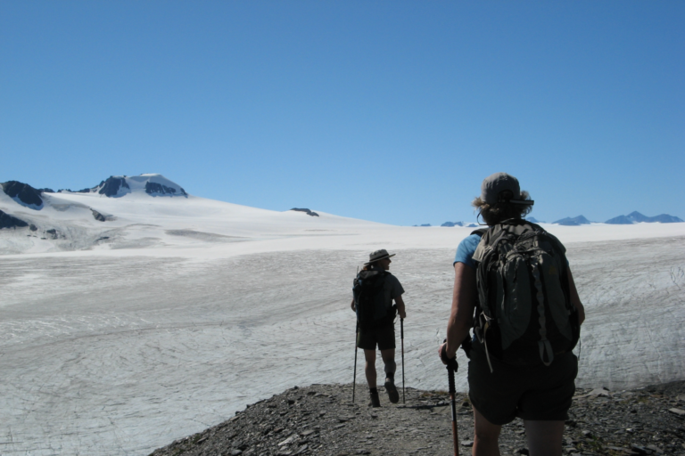 Two hikers stand in front of the Harding Icefield Trail final steps in Kenai Fjords National Park.