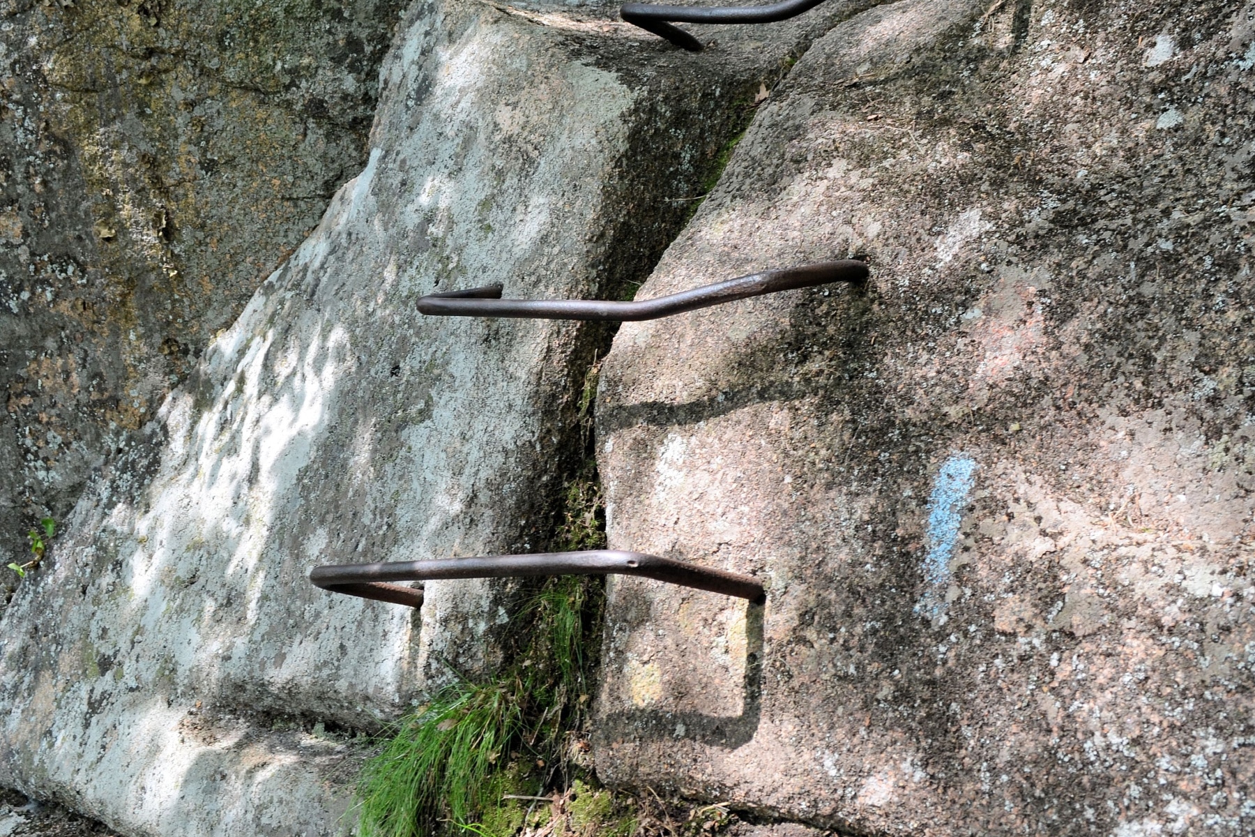 The rungs of the Precipice Trail in Acadia National Park drilled into the rocks and marked with a blue blaze.