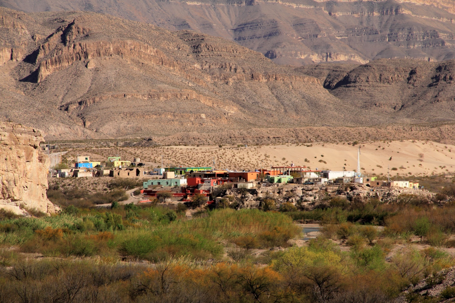 A view of Boquillas, Mexico, with bright colored buildings, as seen from Big Bend National Park. 