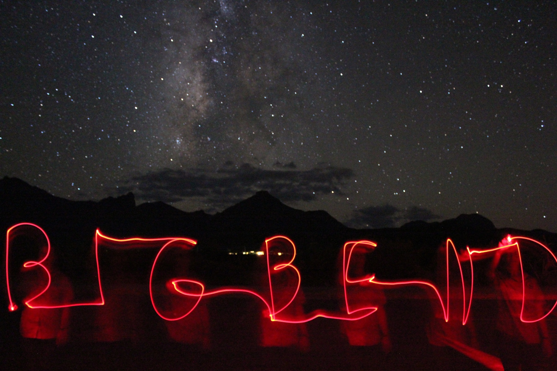 Night skies above the mountains with the words "Big Bend" spelled out in red letters. 