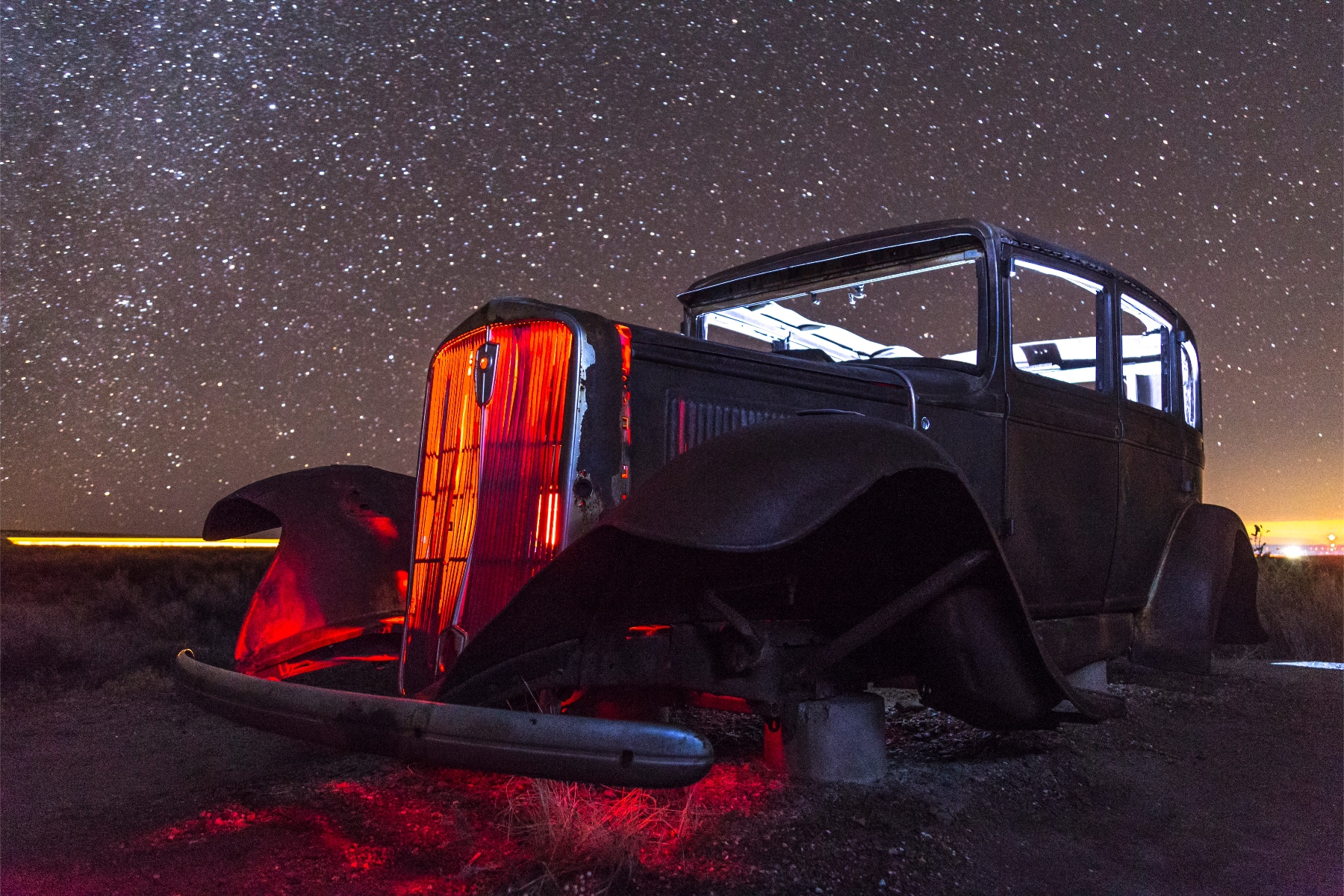 A broken down Studebaker glowing in the night skies of Petrified Forest National Park. 