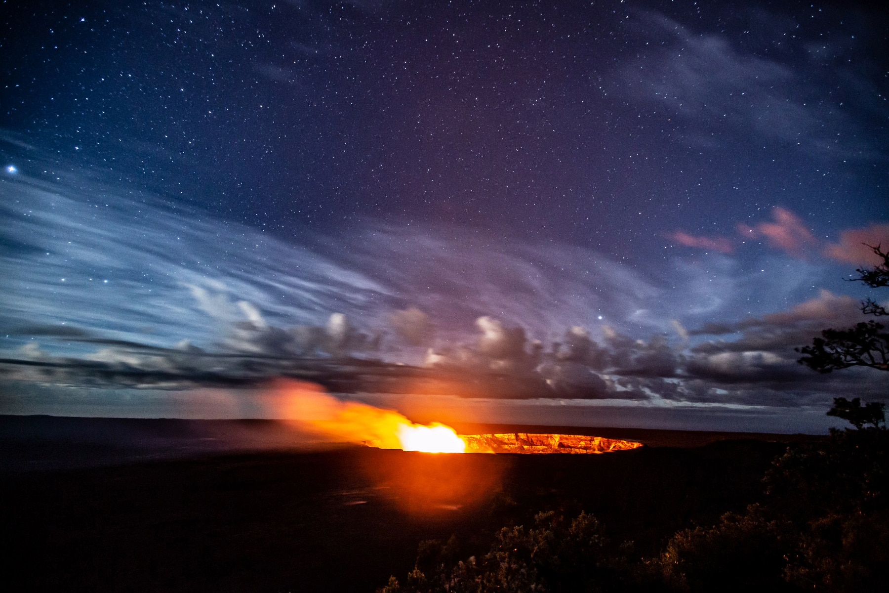 Hawaii Volcanoes National Park stargazing with a fire in the center of the screen. 