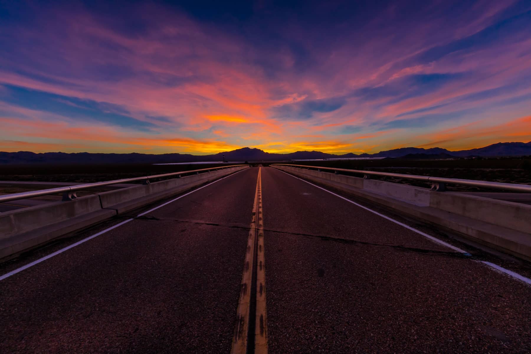 A rainbow of colors during a sunset on a two lane highway in Nevada part of the Dark Sky Park road trip
